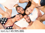 Multicultural group of friends embraced together at the beach . Стоковое фото, агентство Ingram Publishing / Фотобанк Лори