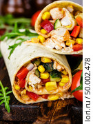 Burritos wraps with chicken meat and vegetables on wooden background. Стоковое фото, агентство Ingram Publishing / Фотобанк Лори