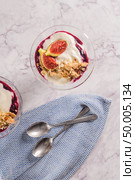 Figs pudding parfait with yogurt, blueberry jam, figs, hazelnut, and cookies in glass on white marble background. Flatlay top view. Стоковое фото, агентство Ingram Publishing / Фотобанк Лори