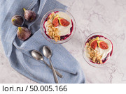 Figs pudding parfait with yogurt, blueberry jam, figs, hazelnut, and cookies in glass on white marble background. Flatlay top view. Стоковое фото, агентство Ingram Publishing / Фотобанк Лори