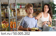 Capricious teenage boy wants to buy lot of sweets, but his mother does not allow him. Family quarrel in the supermarket. Стоковое видео, видеограф Яков Филимонов / Фотобанк Лори