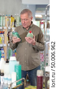 Mature male customer diligently picking out dishwashing liquid. Стоковое видео, видеограф Яков Филимонов / Фотобанк Лори