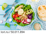 Bowl with grilled chicken meat, bulgur  and fresh vegetable salad of radish, tomatoes, avocado, kale and spinach leaves. Healthy and delicious summer lunch. Top view. Стоковое фото, агентство Ingram Publishing / Фотобанк Лори