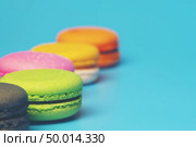 Cake macaron or macaroon on turquoise background from above, colorful almond cookies, pastel colors, vintage card. Стоковое фото, агентство Ingram Publishing / Фотобанк Лори