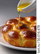 Golden honey drizzling over freshly baked brioche. Стоковое AI-изображение, AI-художник Юрий Поздников / Фотобанк Лори
