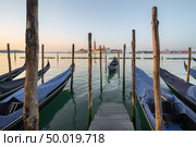 Gondolas moored near pier with the view on San Giorgio Maggiore, Venice. Стоковое фото, агентство Ingram Publishing / Фотобанк Лори