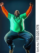 Overweight man standing with his arms raised in the air in celebration and excitement. Стоковое AI-изображение, AI-художник Данила Большаков / Фотобанк Лори