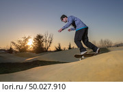 Skateboarder practice on a pump track park on a sunny summer day. Стоковое фото, агентство Ingram Publishing / Фотобанк Лори