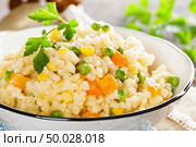 Bulgur wheat boiled with carrot, green peas and corn, healthy vegan diet. Стоковое фото, агентство Ingram Publishing / Фотобанк Лори