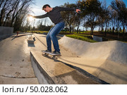 Skateboarder on a grind at sunset at the local skatepark. Стоковое фото, агентство Ingram Publishing / Фотобанк Лори