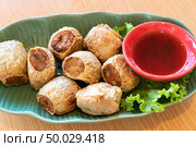 Hoi Jo, Deep Fried Crab Meat Rolls with sweet plum sauce. Thai street food and restaurant cuisine on wooden table. Стоковое фото, агентство Ingram Publishing / Фотобанк Лори