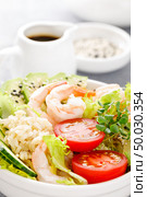Hawaiian poke bowl with shrimps, rice and vegetables, healthy Buddha bowl with prawns, rice, avocado, cucumber, tomato and lettuce. Стоковое фото, агентство Ingram Publishing / Фотобанк Лори