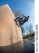 Bmx Bike Stunt Wall Ride on a skatepark. Стоковое фото, агентство Ingram Publishing / Фотобанк Лори