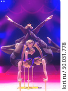 Belarus, Gomel, April 1, 2018. Gomel State Circus.Acrobatic girls perform a trick under blue stage lights. Редакционное фото, фотограф Лазаренко Светлана / Фотобанк Лори
