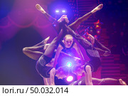 Belarus, Gomel, April 1, 2018. Gomel State Circus.Acrobatic girls perform a trick under blue stage lights. Редакционное фото, фотограф Лазаренко Светлана / Фотобанк Лори