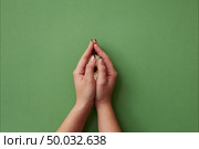 Forming a heart sign from beautiful multicolored pastel flowers with female hands on a green background. Stop motion animation. Flat lay.. Womans hands open the appearing tender gerberas and form a heart symbol from flowers on a green background. Стоковое фото, агентство Ingram Publishing / Фотобанк Лори