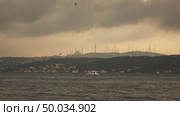 Picturesque seascape to a historical part of old sity Istanbul with antique mosque in a sunlight at sunset sky.. Beautiful seascape with bank of old historical buildings of Istanbul Turkey with ancient Mosque at sunset in summer. Стоковое фото, агентство Ingram Publishing / Фотобанк Лори