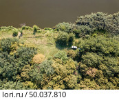 Natural ladscape with dreen trees, river bank, white car on a meadow. Aerial view from drone. Top view.. Aerial view from drone recreation place on a bank of river. Top view green trees, meadow and white car. Top view. Стоковое фото, агентство Ingram Publishing / Фотобанк Лори