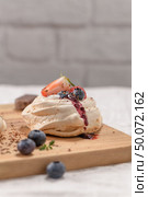 Small pavlova cakes with fresh raspberries and blueberries. Стоковое фото, агентство Ingram Publishing / Фотобанк Лори