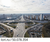 Aerial view from the drone on the city with modern houses and a junction of Odessa square with road interchange in the form of a quatrefoil against the sky on an autumn day. Kiev, Ukraine. Kiev, Ukraine panoramic view of the city with high-rise buildings and a road junctionof Odessa square in the shape of a quatrefoil against the sky. Aerial view from the drone. Редакционное фото, агентство Ingram Publishing / Фотобанк Лори