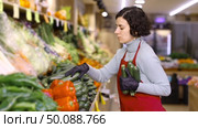 Adult woman seller puts zucchini on display. Стоковое видео, видеограф Яков Филимонов / Фотобанк Лори
