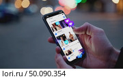 Scrolling through social media app on smartphone in vibrant urban nightscape. Стоковое AI-видео, аниматор Владимир Федоров / Фотобанк Лори