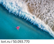Aerial view of young woman swimming on the pink swim ring in the transparent turquoise sea in Oludeniz,Turkey. Summer seascape with girl, beautiful waves, azure water in sunny day. Top view from drone. Aerial view of young woman swimming on the pink swim ring. Стоковое фото, агентство Ingram Publishing / Фотобанк Лори