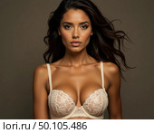 Captivating portrait of a woman confidently presenting exquisite lingerie. The warm ambiance enhances her beauty as she embodies poise and style, surrounded by neutral tones Generative AI. Стоковое AI-изображение, AI-художник Юлия Петровская / Фотобанк Лори