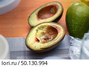 Cross-section of an overripe avocado cut in half, showcasing its soft texture and brownish flesh. Стоковое фото, фотограф Татьяна Степанищева / Фотобанк Лори