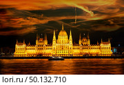 Facade of illuminated Budapest Parliament under cloudy sky, Hungary. Стоковое фото, агентство Ingram Publishing / Фотобанк Лори
