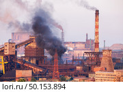 Industrial landscape in Ukraine. Steel factory with smog at sunset. Pipes with smoke. Metallurgical plant. steelworks, iron works. Heavy industry. Ecology problems, atmospheric pollutants. Стоковое фото, агентство Ingram Publishing / Фотобанк Лори