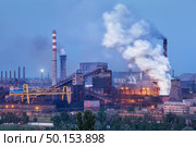 Metallurgical plant with white smoke at night. Steel factory with smokestacks . Steelworks, iron works. Heavy industry. Air pollution from smokestacks, ecology problems. Industrial landscape at twilight. Стоковое фото, агентство Ingram Publishing / Фотобанк Лори