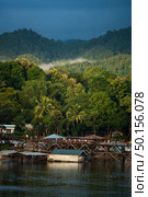 Kanchanaburi, Thailand, June 29, 2019 : Beautiful sunrise scene in early morning at old an long wooden bridge at Sangklaburi,Kanchanaburi province, Thailand. Редакционное фото, агентство Ingram Publishing / Фотобанк Лори