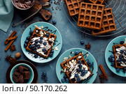 Chocolate belgian waffles with ice cream and fresh blueberry on blue background, top view. Стоковое фото, агентство Ingram Publishing / Фотобанк Лори