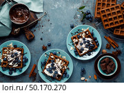 Chocolate belgian waffles with ice cream and fresh blueberry on blue background, top view. Стоковое фото, агентство Ingram Publishing / Фотобанк Лори