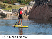 Stand up paddleboarding on lake. Watersport on lake. Tourist outdoor activity at Lagoa Comprida, Serra da Estrela National Park in Portugal. Стоковое фото, агентство Ingram Publishing / Фотобанк Лори