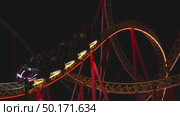 Rollercoaster Night Ride Amusement Park: Illuminated thrill ride traversing loops at night for entertainment. Стоковое видео, видеограф svetograph / Фотобанк Лори
