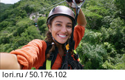 Thrilling zipline adventure through lush green canopy on a sunny day. Стоковое AI-изображение, AI-художник Сергей Толмачёв / Фотобанк Лори