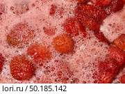 Homemade preparation of strawberry jam. Foam and juice when cooking strawberries. The process of making strawberry jam. Close-up of boiling strawberries. Стоковое фото, фотограф Андрей Жигальцов / Фотобанк Лори