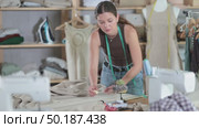 Female seamstress cutting fabric with scissors on worktable. Стоковое видео, видеограф Яков Филимонов / Фотобанк Лори