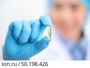 Fish oil capsules with omega 3 and vitamin D in a glass bottle on wooden texture, healthy diet concept. Стоковое фото, агентство Ingram Publishing / Фотобанк Лори