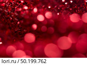 Red bokeh holiday textured Christmas decorations background. Стоковое фото, агентство Ingram Publishing / Фотобанк Лори