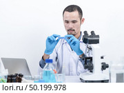 Researcher in the laboratory Studying with chemicals And microscopes. Стоковое фото, агентство Ingram Publishing / Фотобанк Лори