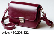 Stylish burgundy leather crossbody bag perfect for everyday use and elegant outings. Стоковое AI-изображение, AI-художник Сергей Толмачёв / Фотобанк Лори