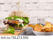 Healthy vegan burger with fresh vegetables and yogurt sauce on rustic kitchen counter top. Стоковое фото, агентство Ingram Publishing / Фотобанк Лори
