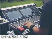 Hand of club party dj mixing music tracks with professional sound mixer device. Disc jockey adjust cross fader knob to regulate track volume and cut songs in the mix. Стоковое фото, агентство Ingram Publishing / Фотобанк Лори