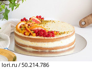 Homemade vanilla birthday cake decorated with orange, peach and gooseberries isolated on table tob. Celebration, party cake. Стоковое фото, агентство Ingram Publishing / Фотобанк Лори