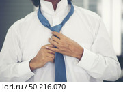 Businessmen are tying necktie. To prepare for the presentation. Стоковое фото, агентство Ingram Publishing / Фотобанк Лори