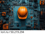 A bright orange construction helmet is placed in the center of an industrial background consisting of many technical elements, levers, switches, buttons and wires on steel-blue panels. The composition symbolizes industrial safety, engineering, mechanics and technology. The contrast of warm orange and cold blue emphasizes attention to detail and creates a visually powerful image. Suitable for industrial safety, manufacturing, construction, engineering and technology themes. Стоковое AI-изображение, AI-художник Анна Кривицкая / Фотобанк Лори