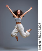 Joyful asian young female jumping happily in casual fashion. Стоковое AI-изображение, AI-художник Olga Didraga / Фотобанк Лори